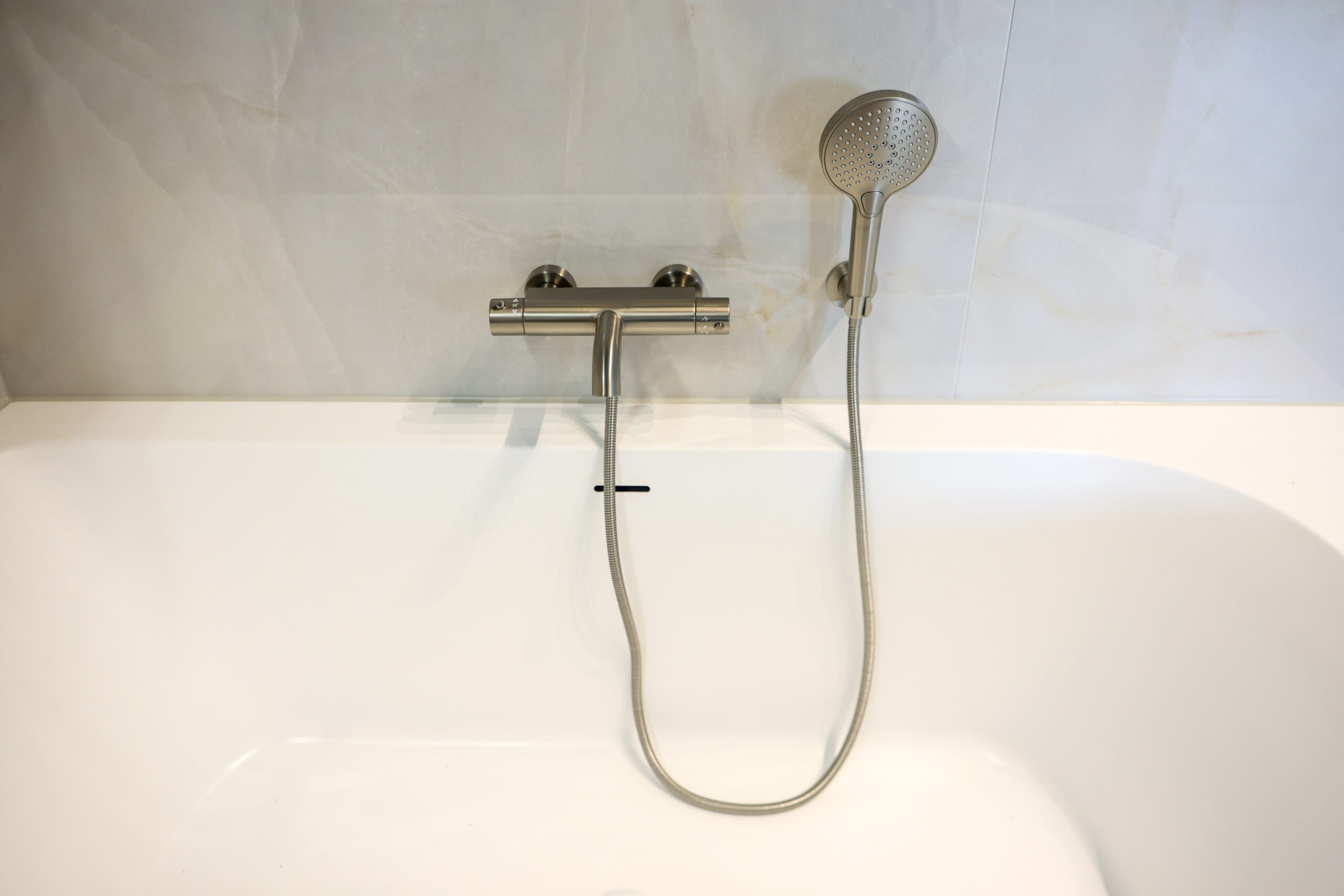 Badkamer met ligbad en glazen badwand