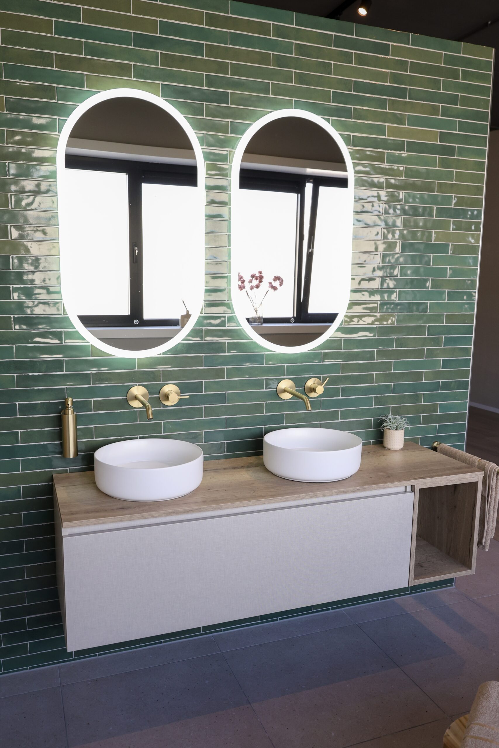 Moderne badkamer met dubbele wastafel en verlichte spiegels